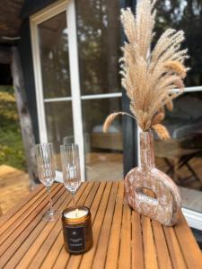 Una mesa con dos vasos y un jarrón con una vela. en ALŪNA house, 