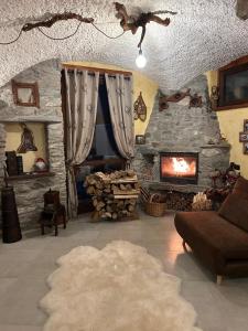 Una sala de estar con chimenea de piedra y un sofá. en La Baita del vecchio GAD, en Oulx
