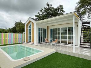 a house with a swimming pool and a patio at บ้านสวนแสงหล้า วิลล่า รีสอร์ท  +17 photos