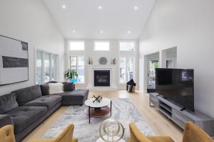 a living room with a couch and a tv at Main Unit Luxury South Windsor Oasis in Windsor