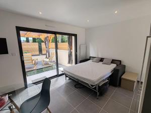 a bedroom with a bed and a sliding glass door at Appart'semaine in Cléguer