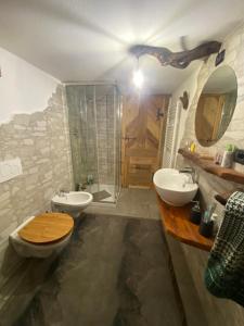 Un baño con dos lavabos, un inodoro y una ducha. en La Baita del vecchio GAD, en Oulx 21 fotos más
