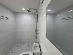 a white bathroom with a shower and a toilet at บ้านสวนแสงหล้า วิลล่า รีสอร์ท 