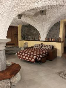 Un dormitorio con una cama en una habitación de piedra. en La Baita del vecchio GAD, en Oulx