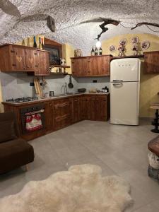 Una cocina con gabinetes de madera y refrigerador. en La Baita del vecchio GAD, en Oulx