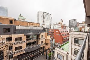 Un horizonte de ciudad con edificios altos y un tren. en Lions Mansion Kabukicho No2, en Tokio