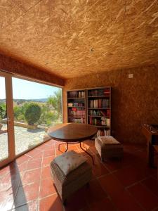 una sala de estar con una mesa y un estante de libros en Monte da Freira, en Bencatel 78 fotos más