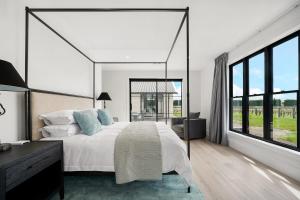 The WhiteHouse Te Whare Ma في مارتينبوره: غرفة نوم بسرير كبير ونافذة كبيرة