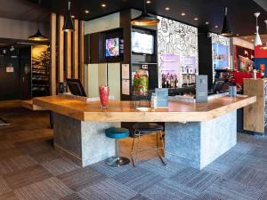 a bar in a restaurant with a counter and stools at Ibis Alès Centre Ville in Alès