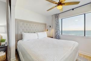 a bedroom with a bed and a large window at Sunset Harbor Palms 1-204 in Navarre