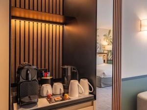 a hotel room with a coffee maker on a shelf at Mercure Le Mans Batignolles - Hotel & Spa in Le Mans +54 photos