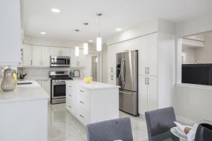 a kitchen with white cabinets and stainless steel appliances at Main Unit Luxury South Windsor Oasis in Windsor