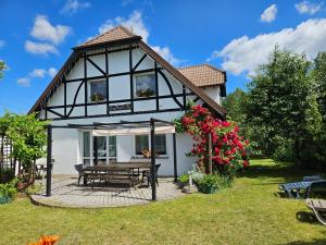 a house with a picnic table in the yard at Villa Paula Pluski in Pluski