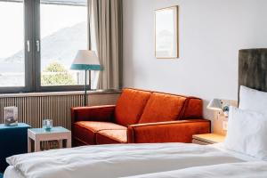 une chambre d'hôtel avec un canapé et un lit dans l'établissement Das Traunsee - Das Hotel zum See 4 Stern Superior, à Traunkirchen