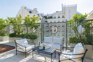 a patio with chairs and a table and a fence at Le Bristol Paris, Oetker Hotels in Paris