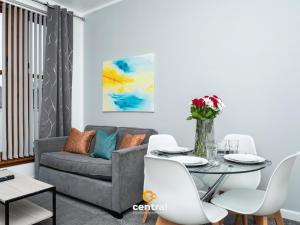 a living room with a couch and a table and chairs at Trades Lane by CENTRAL SERVICED APARTMENTS - Cosy 1 Bedroom - Walk Away From City Quay V&A - Walk to Bus and Train Station - Easy Access to City Centre - Fast Wi-Fi - Fully Equipped - Weekly & Monthly Stay Offers in Dundee