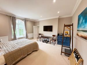 a bedroom with a bed and a desk in it at Moorswater Lodge in Liskeard