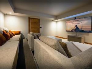 Una sala de estar con dos sofás y un televisor de pantalla plana. en Chalet Ellambra - OVO Network, en Combloux