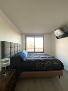 El CerrilloにあるMejor Apartmento Providenciaの窓のある大きなベッドのある寝室