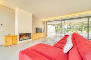 a red couch in a living room with a fireplace at Ideal Property Mallorca - Villa Alzina in Crestatx