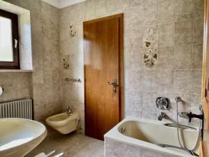 a bathroom with a tub and a toilet and a sink at Kalterer See Hof in Caldaro +21 photos