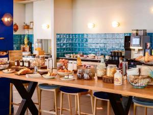une cuisine avec une table avec de la nourriture dessus dans l'établissement Novotel Orléans Chemins De Sologne Demeures De Campagne, à Orléans