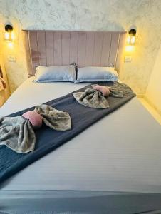 a bed with two blankets and towels on it at Ama boutique in Constanţa