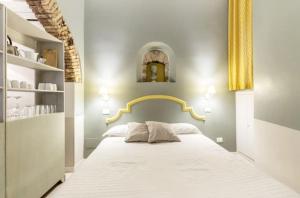 a bedroom with a large white bed with a gold headboard at Trastevere Little Home in Rome