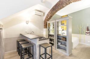 a kitchen with a sink and a counter with stools at Trastevere Little Home in Rome
