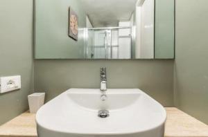 a bathroom with a white sink and a mirror at Trastevere Little Home in Rome +8 photos