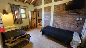 une chambre avec un lit et un mur de briques dans l'établissement Cabañas Altos de la Bodega, à San Rafael 14 autres photos