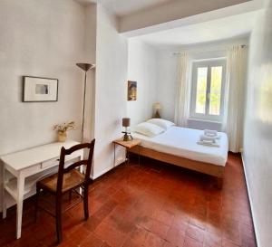 ein Schlafzimmer mit Bett, Schreibtisch und Fenster in der Unterkunft Leucate in Leucate