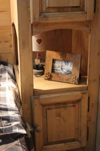 a wooden cabinet with a picture and a picture frame at Chalet des pistes in Megève