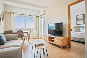 a living room with a couch and a tv and a bed at Alcam Terrassa in Terrassa