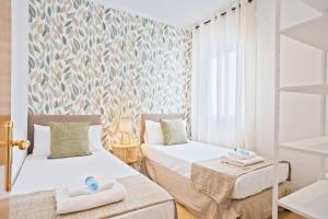 two beds in a room with a wall mural at Alcam Terrassa in Terrassa