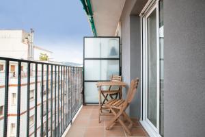 a balcony with two chairs and a table on it at Alcam Terrassa in Terrassa