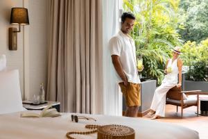 a man and woman looking out of a window in a hotel room at METT Singapore in Singapore