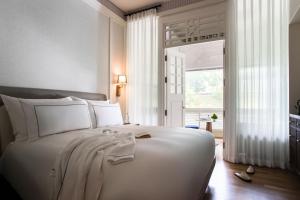 a bedroom with a large white bed and a window at METT Singapore in Singapore