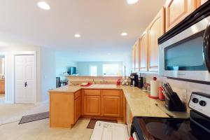 a large kitchen with wooden cabinets and a sink at The Seaside Condo in Westport in Westport +32 photos