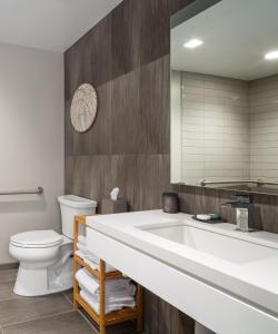 a bathroom with a sink and a toilet and a mirror at The Windsor Suites in Philadelphia