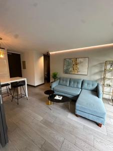 a living room with a blue couch and a table at Adorable department con modernas terminaciones in Santiago +1 photo