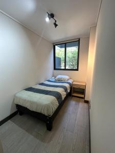 a small bedroom with a bed and a window at Adorable department con modernas terminaciones in Santiago
