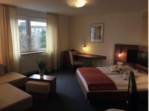 a hotel room with a bed and a desk at Hotel Kurpfalz in Speyer