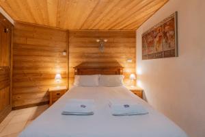 a bedroom with a bed in a wooden room at Clos Donne Apartment - Snow and Trek- Essert Romand in Essert-Romand