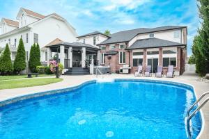 a swimming pool in front of a house at Main Unit Luxury South Windsor Oasis in Windsor