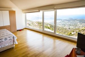 a bedroom with a bed and large windows at Viva B&B in Anavyssos