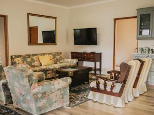 a living room with a couch and a tv at Ontevreden Farm in Montagu