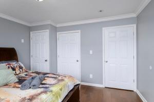 a bedroom with a bed with two white doors at American Pharaoh Twin Spires Suite in Jeffersonville
