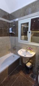 a bathroom with a sink and a bath tub next to a sink at Golden Sun House I in Abu Simbel