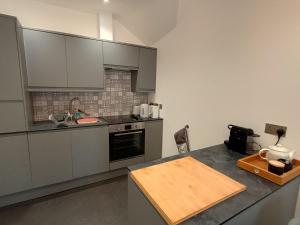 cocina con armarios grises y encimera en Nos-da, en Menai Bridge